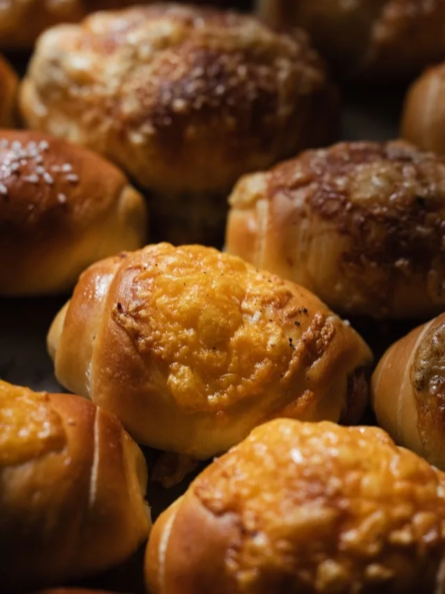 Gros plan sur des salt breads dorés, fromage gratiné sur le dessus.