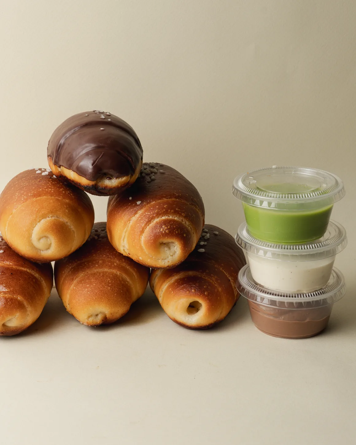 Une pyramide de salted breads dorés et trois pots de dips : pandan, cream cheese, chocolat.